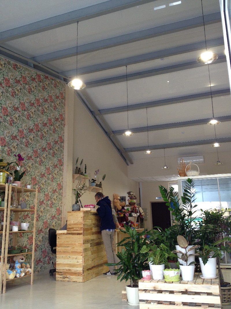 Интерьер цветочного магазина с белыми глянцевыми натяжными потолками.